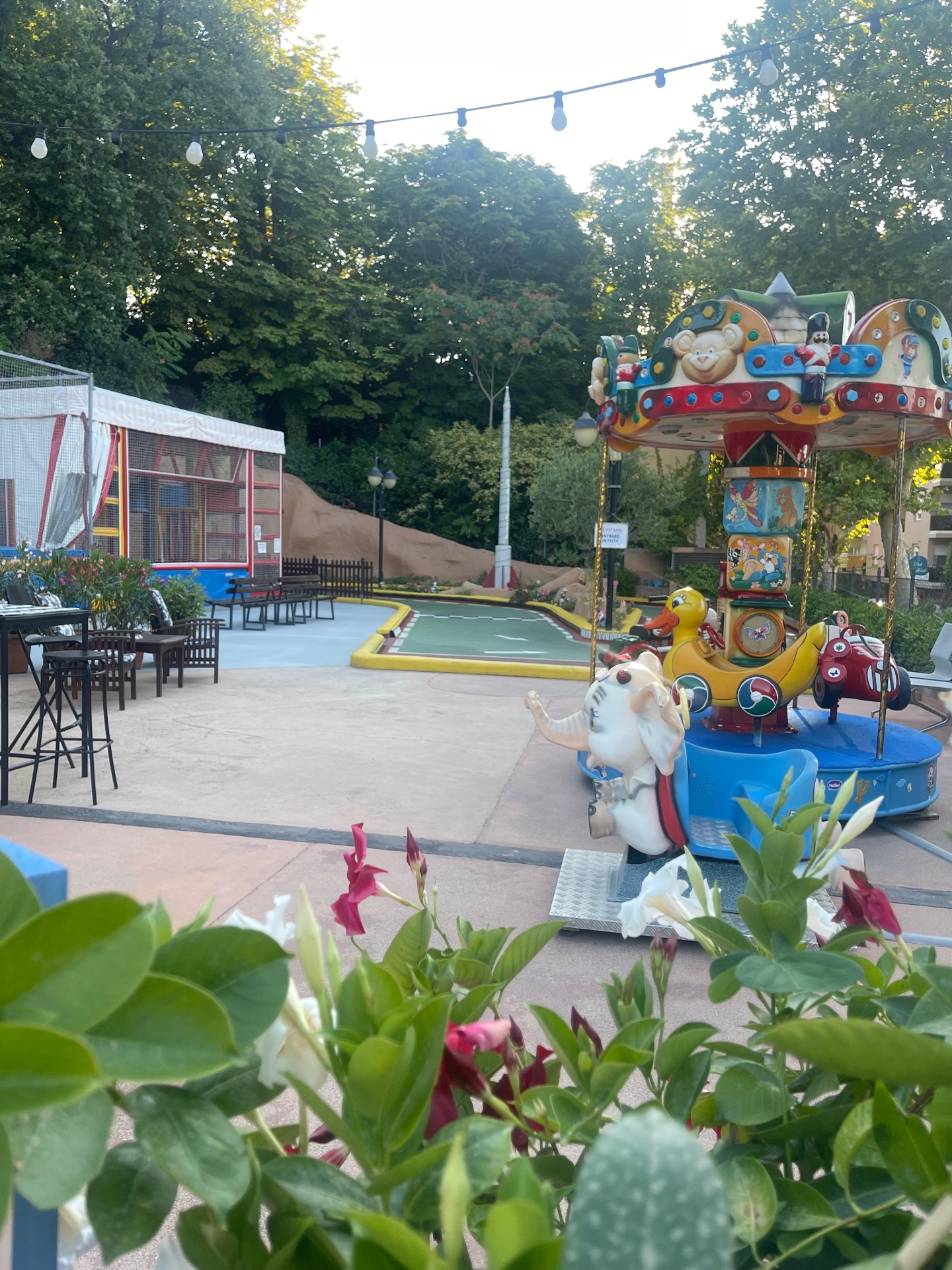 I tavolini del bar all'ombra con vista sulle giostre e sul percorso di minigolf